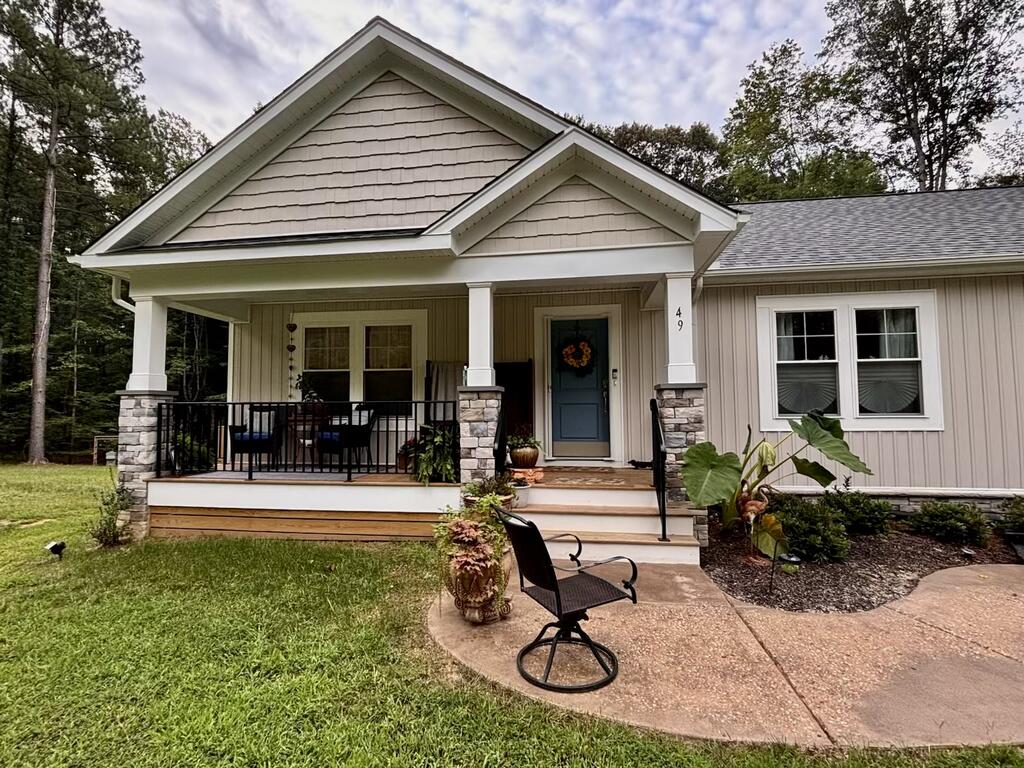 Home exterior with a covered porch, stone-based columns, and a blue front door.