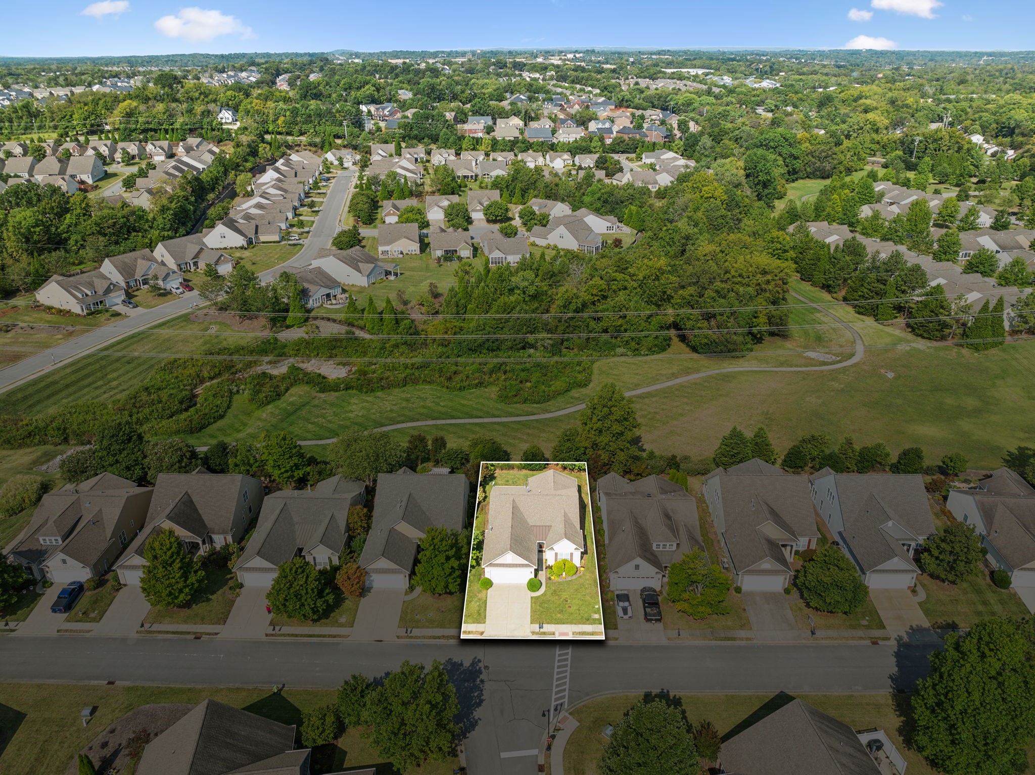 Aerial view of 1158 Bastion Cir highlighted beside a grassy greenway and winding path.