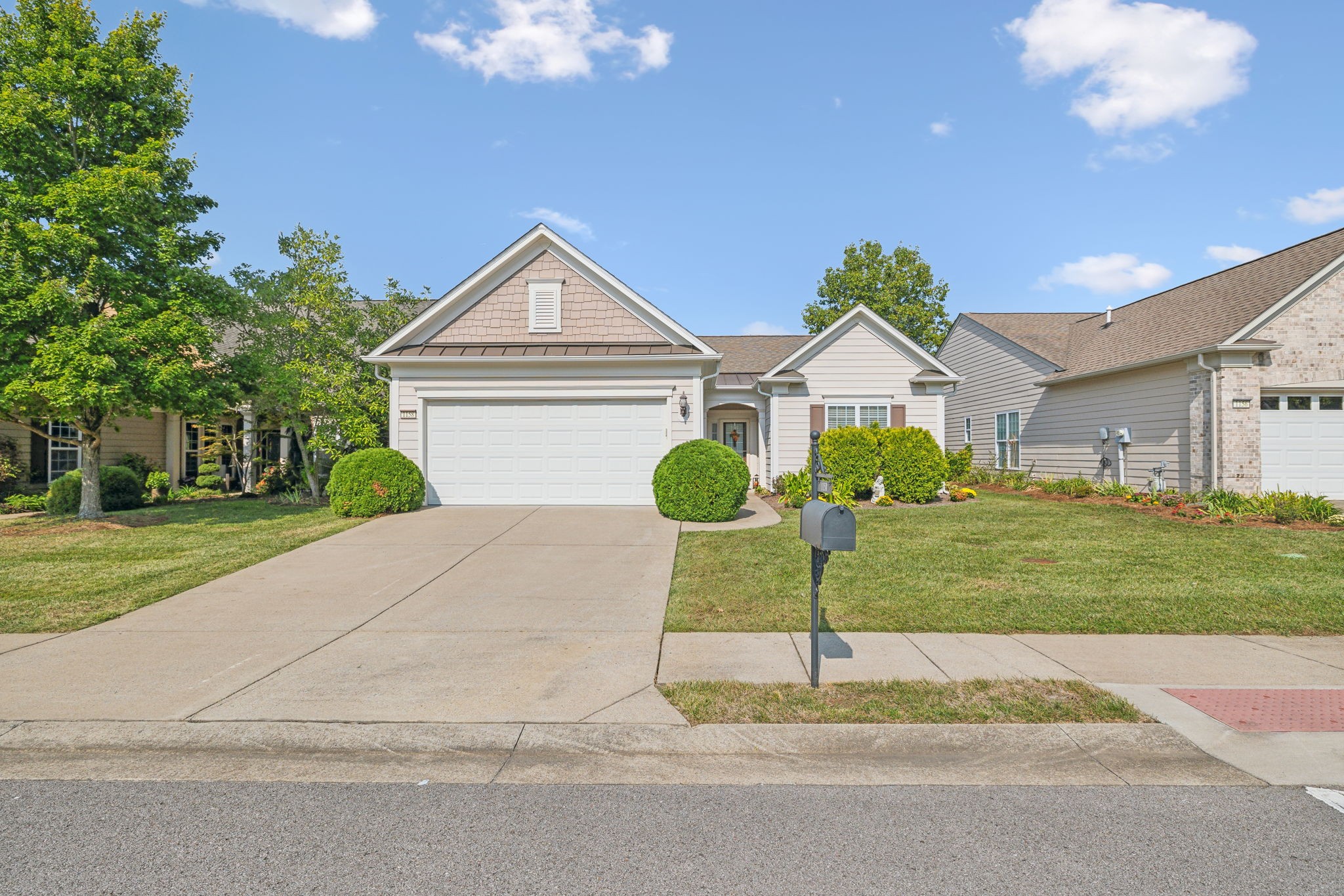 Single-story home with a two-car garage, landscaped front yard, and mailbox beside the driveway.