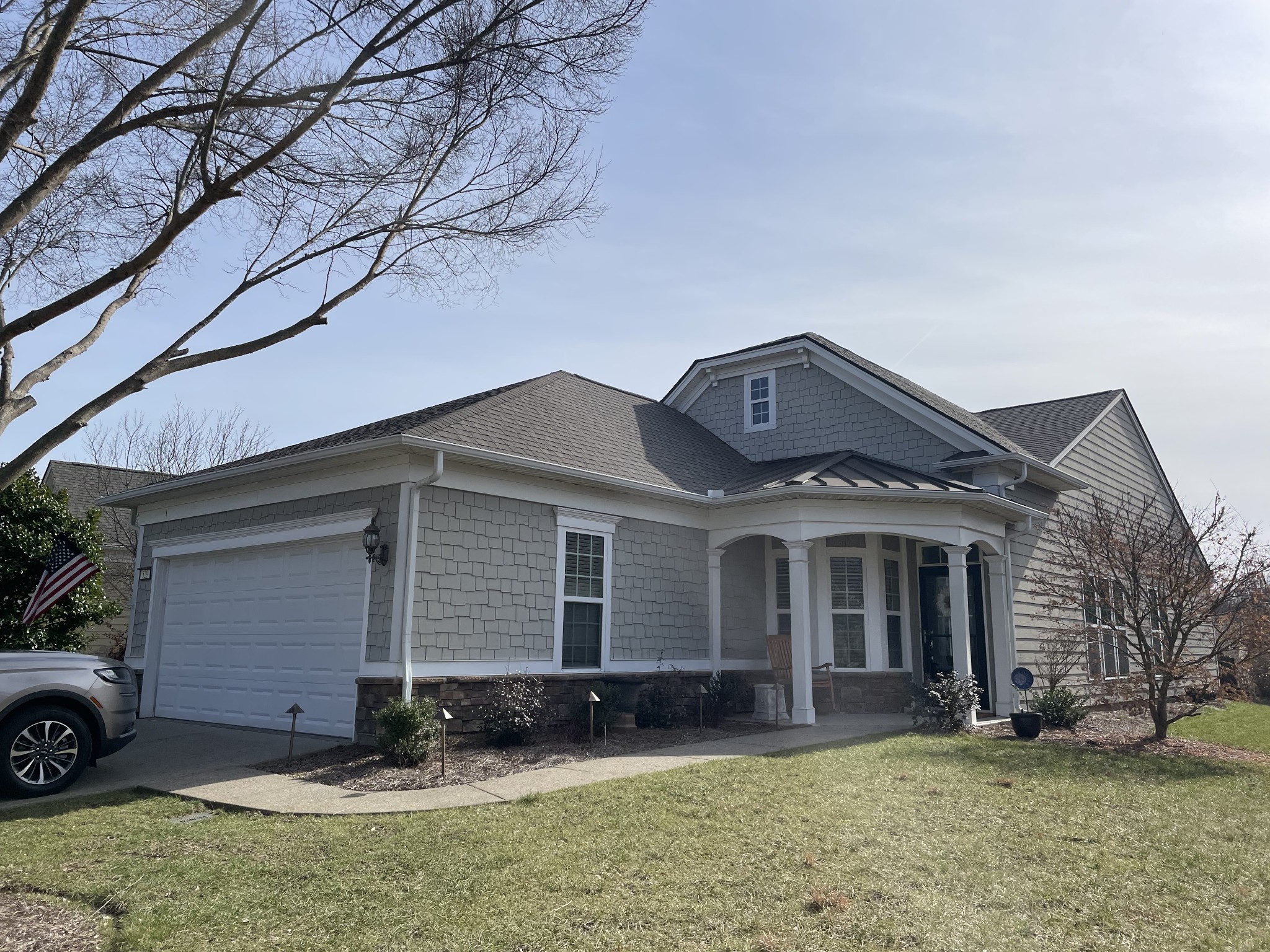 Gray shingle-sided house with an attached garage and covered front porch.