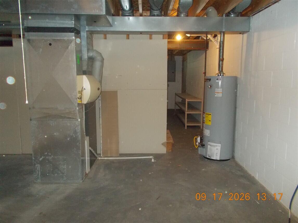 Basement mechanical room with a furnace, exposed ductwork, and a water heater.