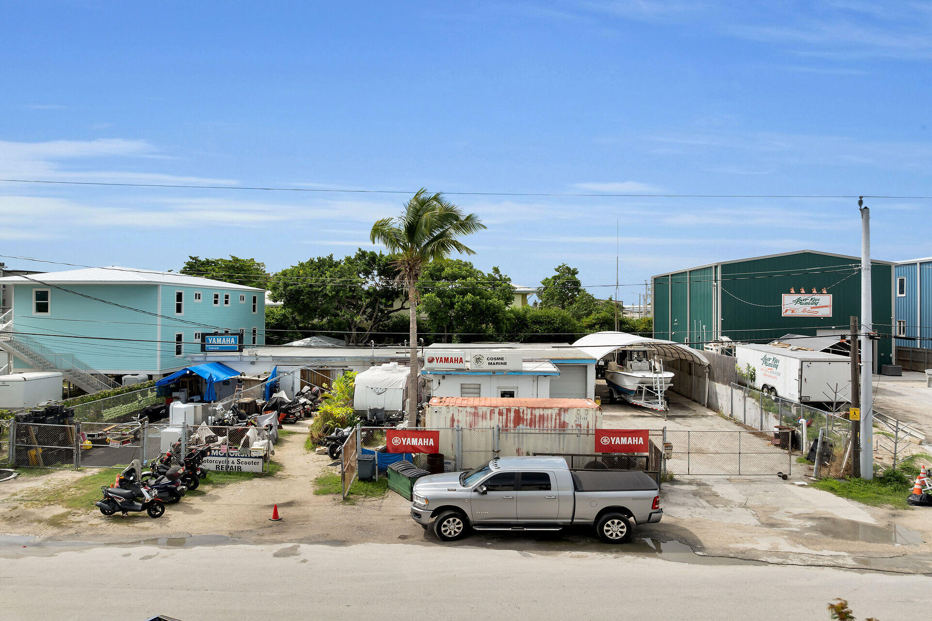 Commercial marine and powersports yard with boats, motorcycles, and a Yamaha storefront.