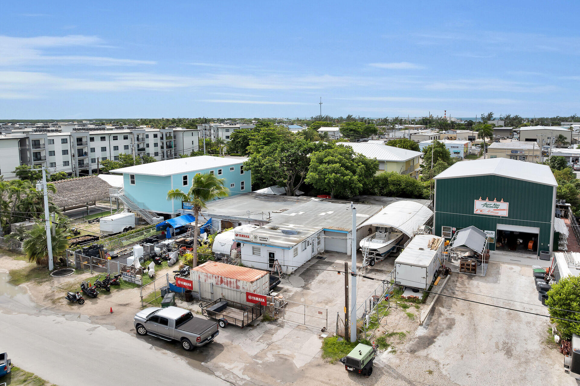 Aerial view of a marine service yard with boats, workshops, and trailers.