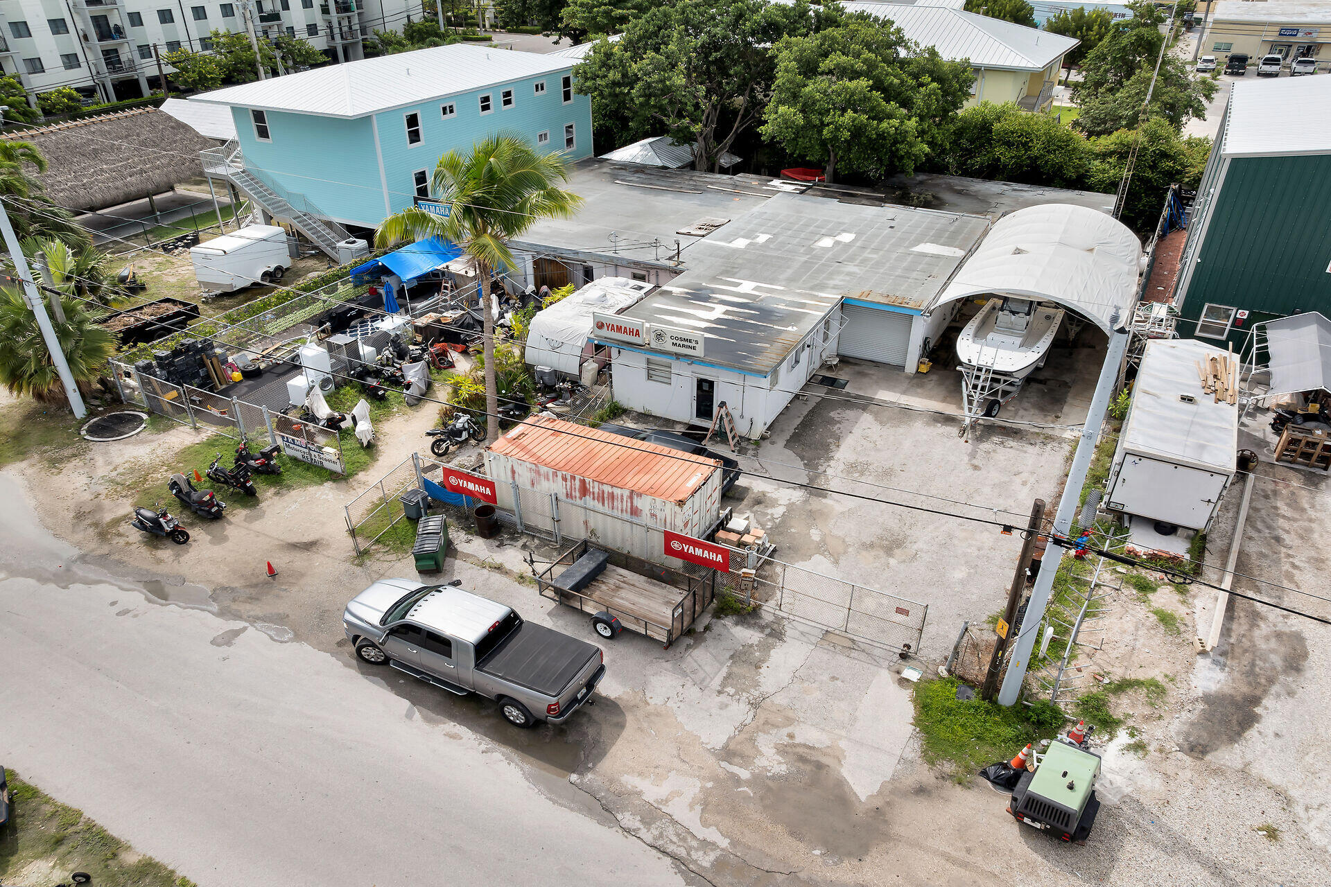 Aerial view of a marine workshop and boat yard with a covered boat bay and Yamaha signs.