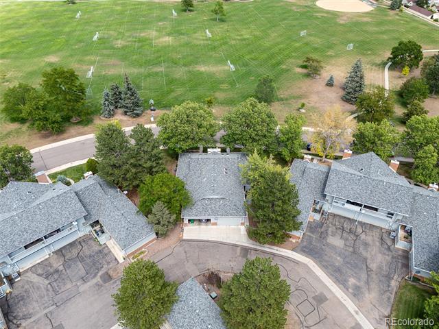 Aerial view of several homes beside a large green athletic field.