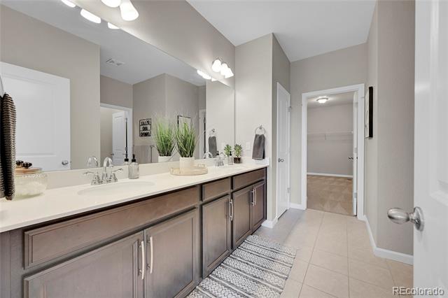 Bathroom with a long double-sink vanity, dark wood cabinets, and a patterned runner.