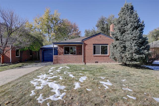 Red-brick single-story house with a blue garage door, driveway, and snow patches on the lawn.