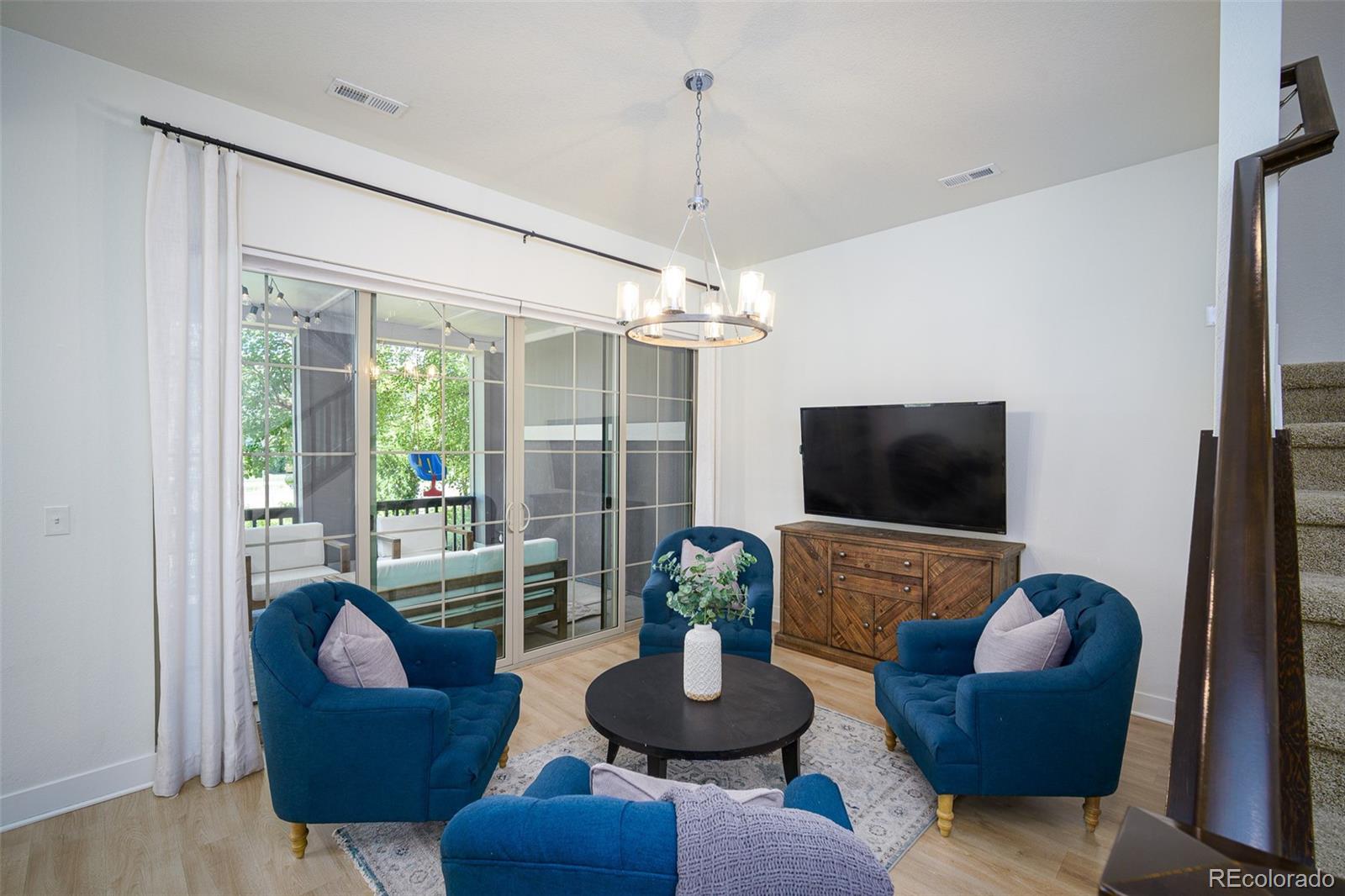 Living room with blue armchairs, a round coffee table, and sliding glass doors to a patio.