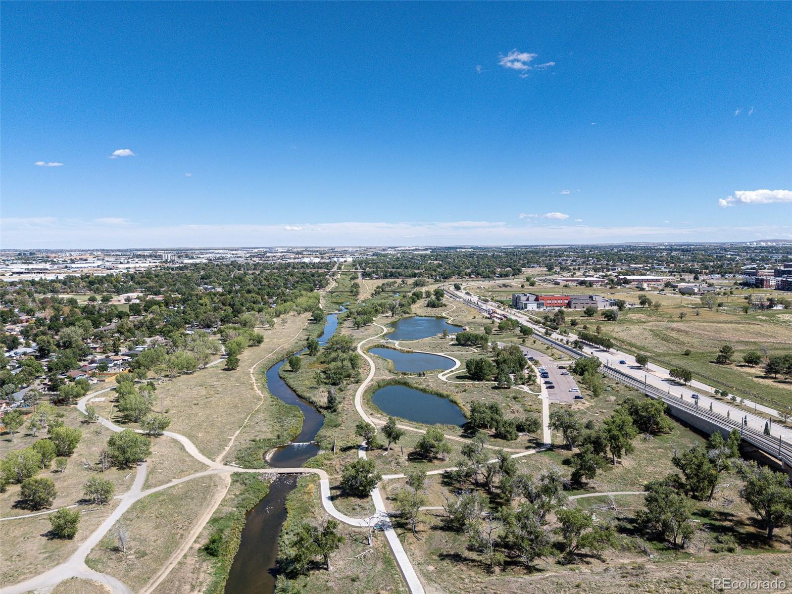 Aerial view of a Denver greenway with winding water, ponds, and walking paths.