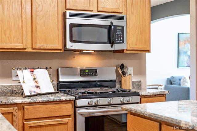 Kitchen with light wood cabinets, stainless steel appliances, granite counters, and a gas range.