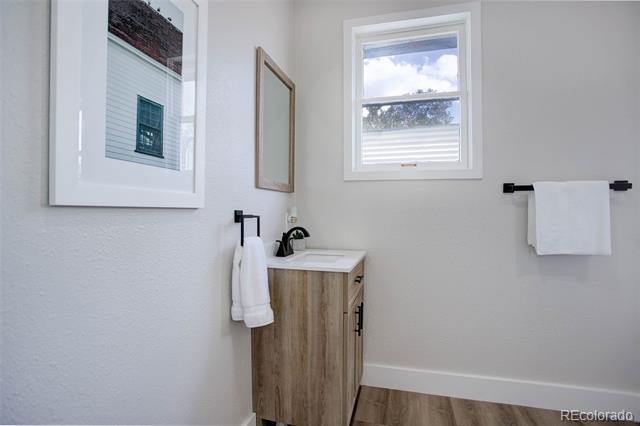 Bathroom with a wood-look vanity, white towels, and a window.