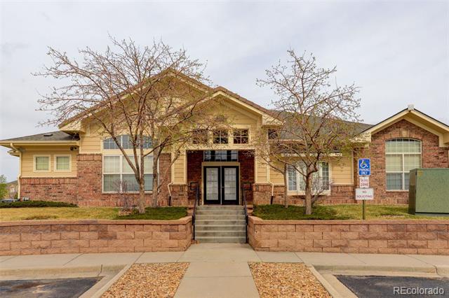 Residential building entrance with brick facade, front steps, and a paved walkway.