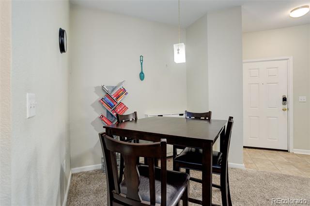 Dining area with a dark wood table and chairs beside the unit’s entry door.