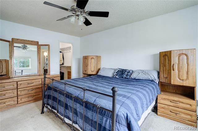 Bedroom with blue striped bedding, a black metal bed frame, and matching wood dressers.