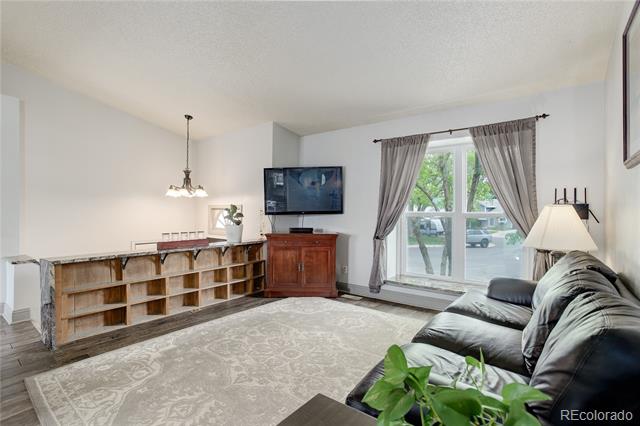 Living room with rustic built-in shelving, a gray sectional, and a large curtained window.