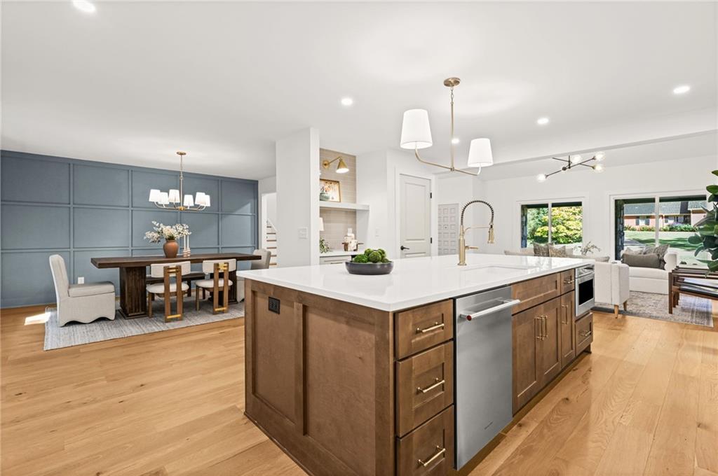 Open-plan kitchen with a large wood island, white countertops, and blue-paneled dining area.