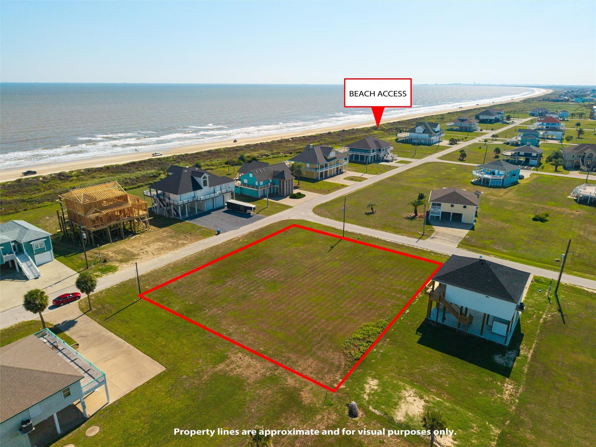 Aerial view of vacant coastal lot outlined in red near beach access and shoreline.