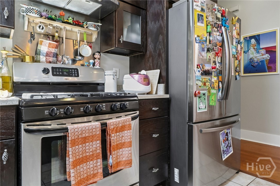 Kitchen with dark wood cabinets, stainless steel appliances, and a refrigerator covered in magnets.