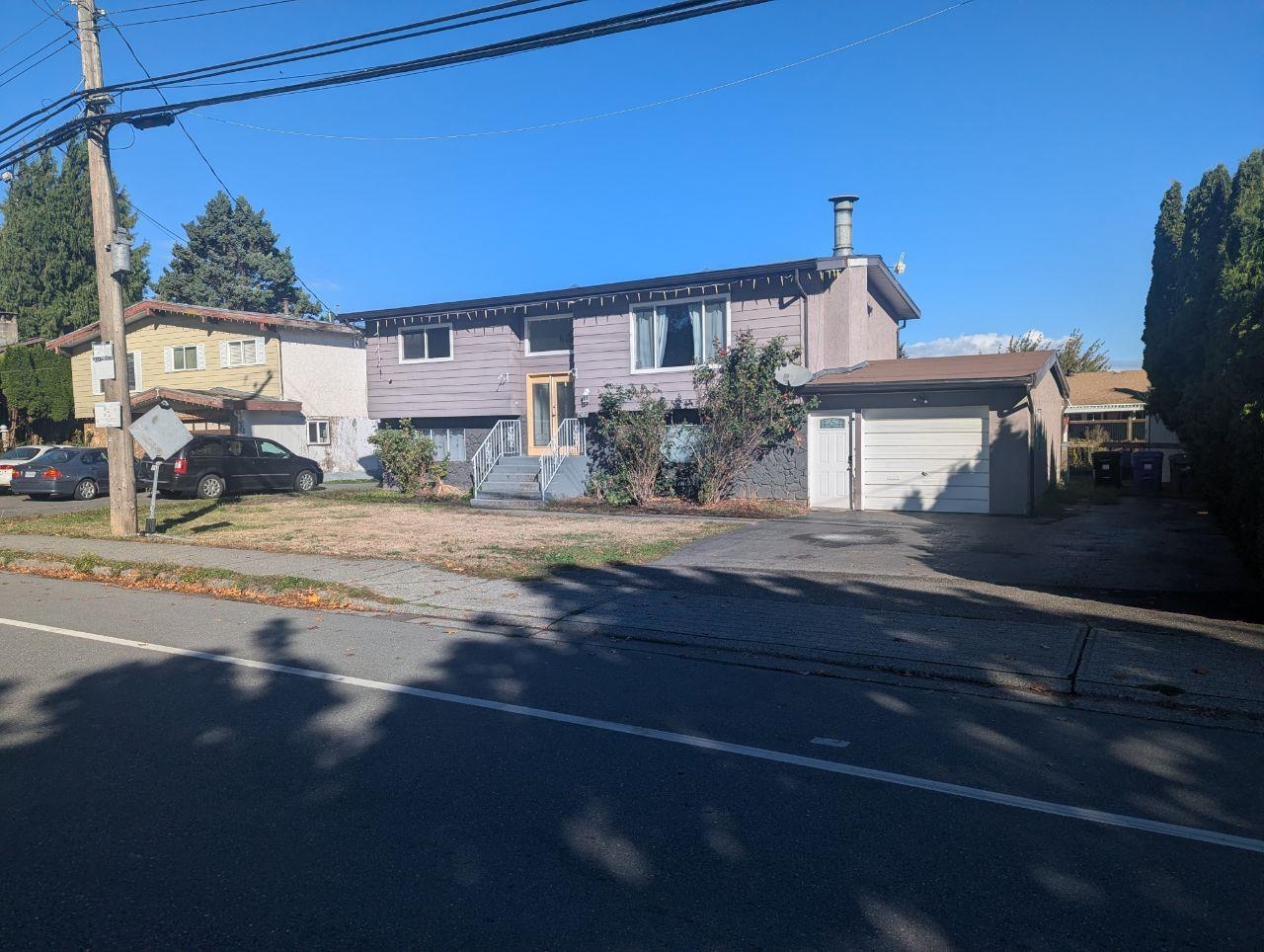 Split-level house with mauve siding, front steps and an attached garage beside the street.