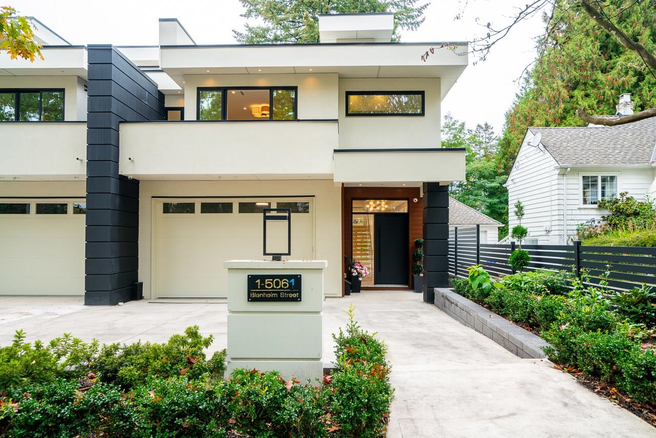 Modern two-story home with a white and charcoal facade, broad driveway, and landscaped front garden.