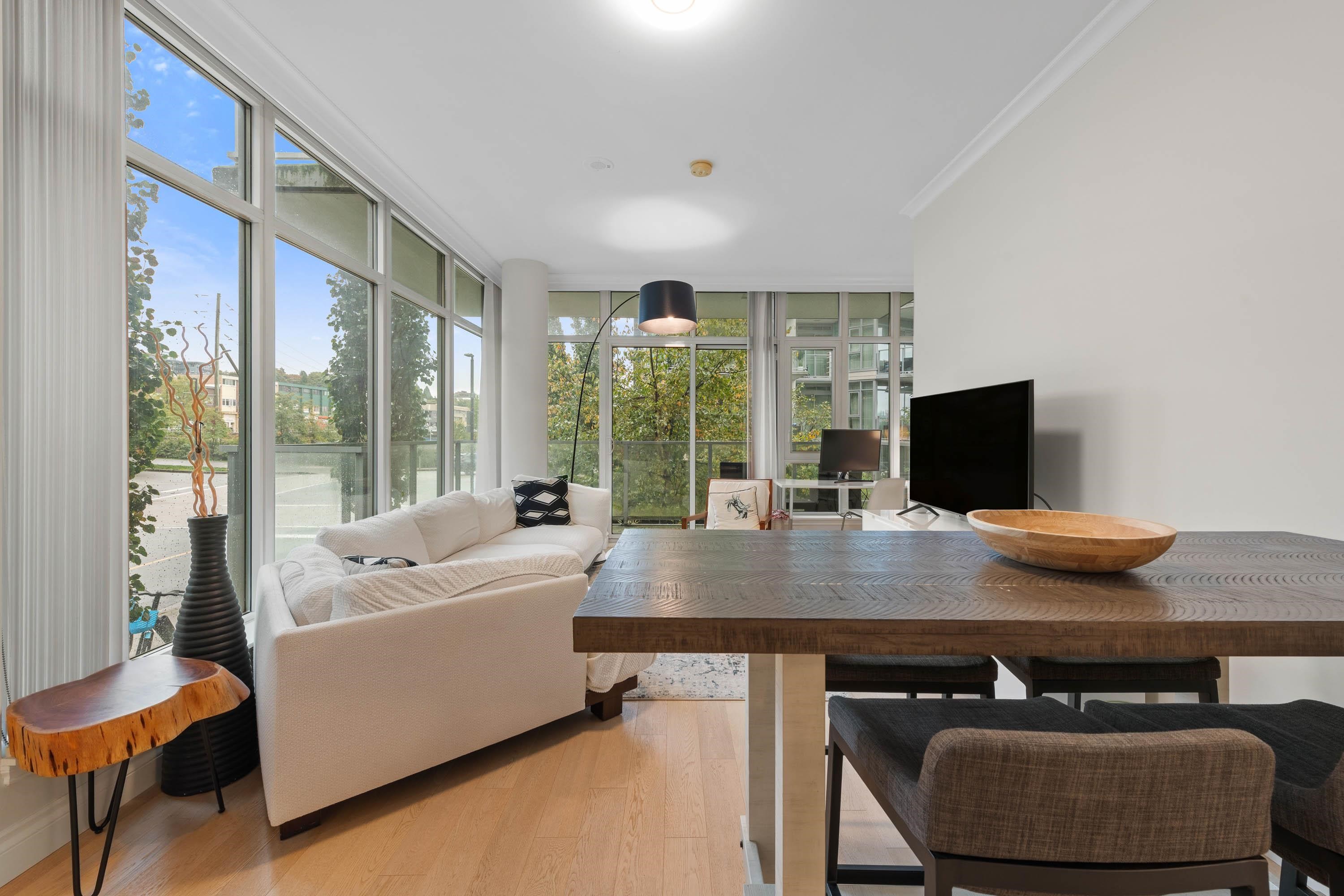 Open-plan living and dining area with floor-to-ceiling windows and a white sofa.