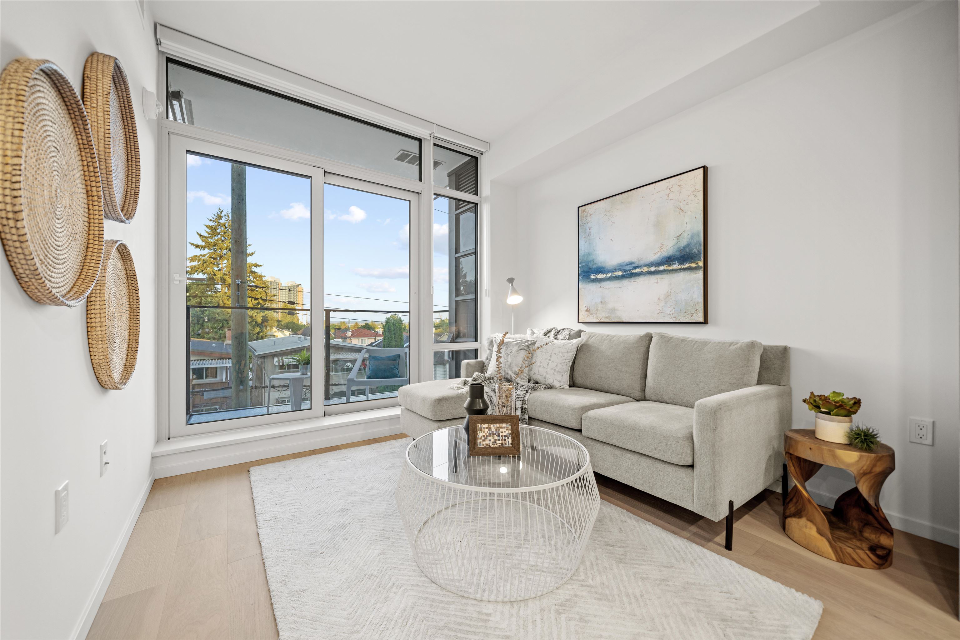 Bright condo living room with a pale sectional and floor-to-ceiling windows overlooking a balcony.