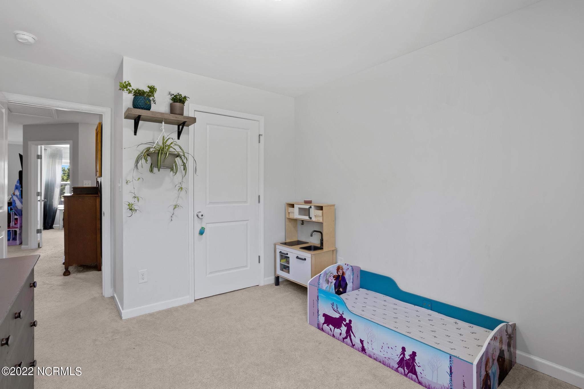 Child's bedroom with a Frozen-themed toddler bed and toy kitchen.