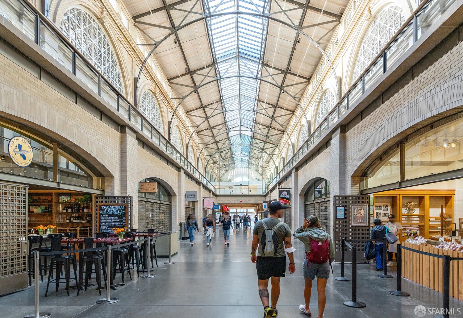 Ferry Building marketplace corridor with a vaulted glass roof and food stalls.
