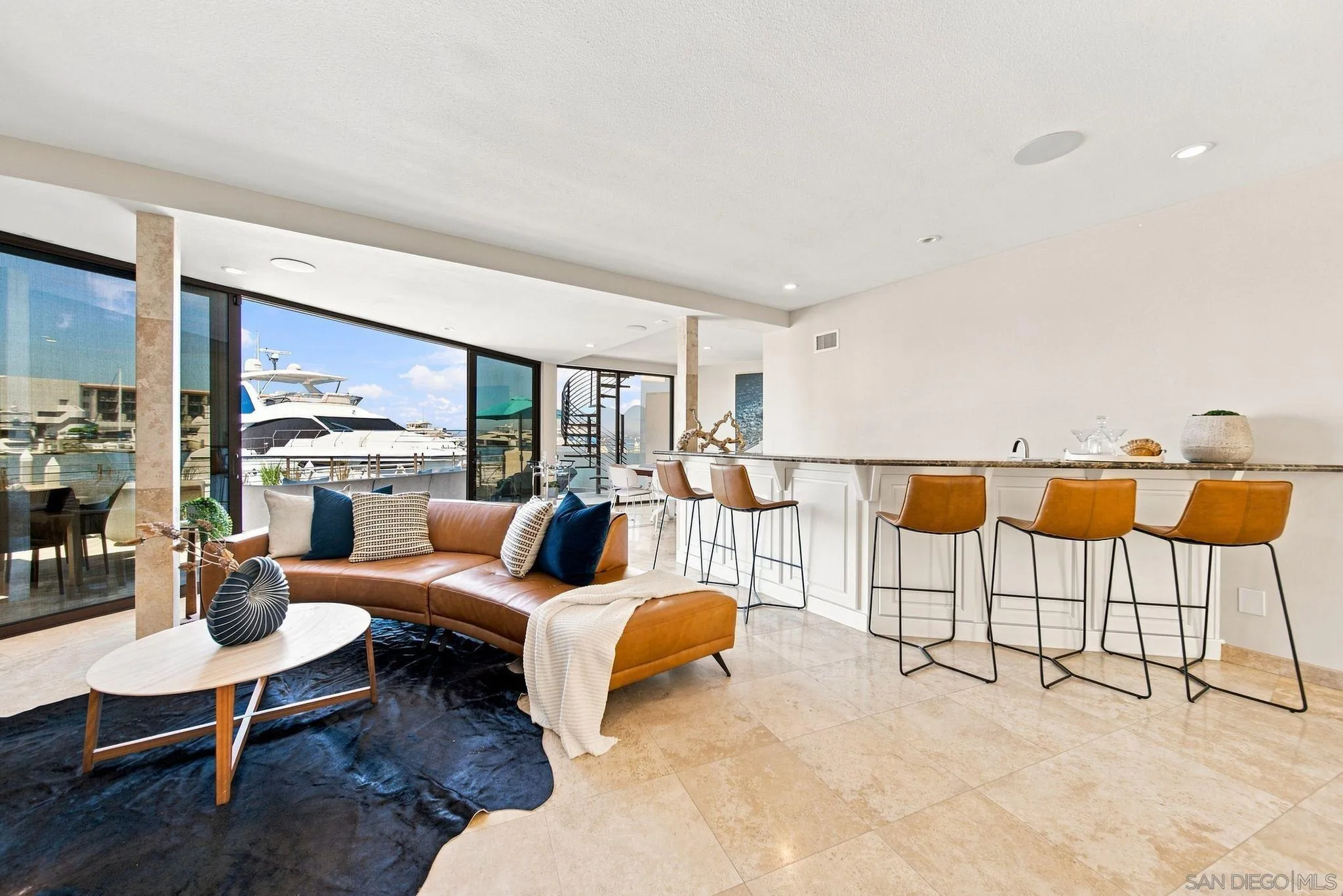 Open-plan living room and kitchen with marina views through floor-to-ceiling glass doors.