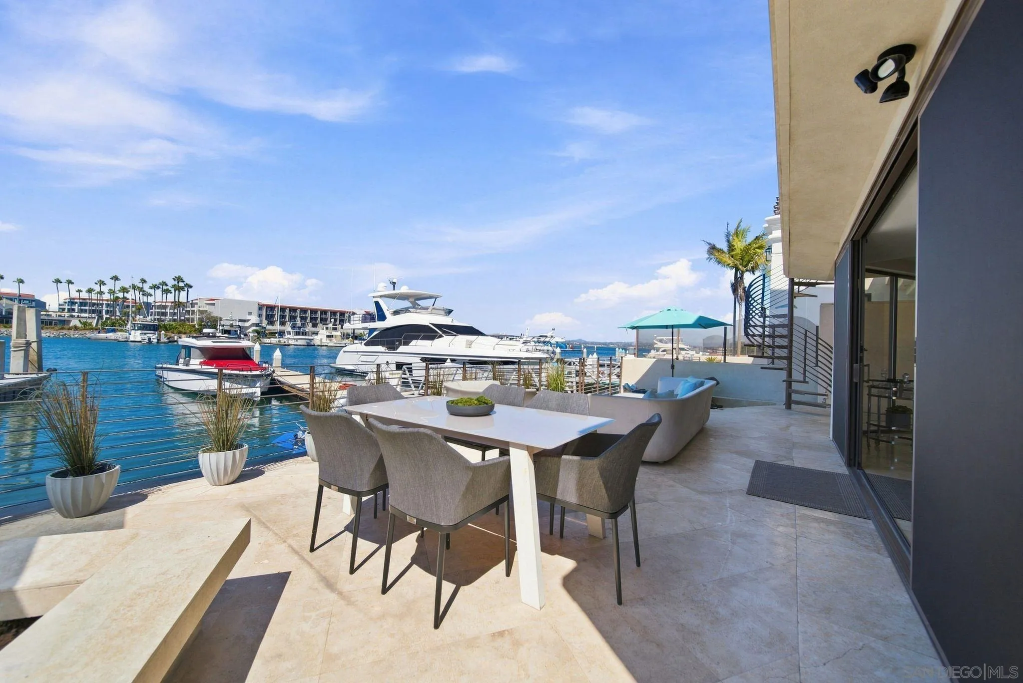 Waterfront patio with outdoor dining and lounge seating overlooking a marina.