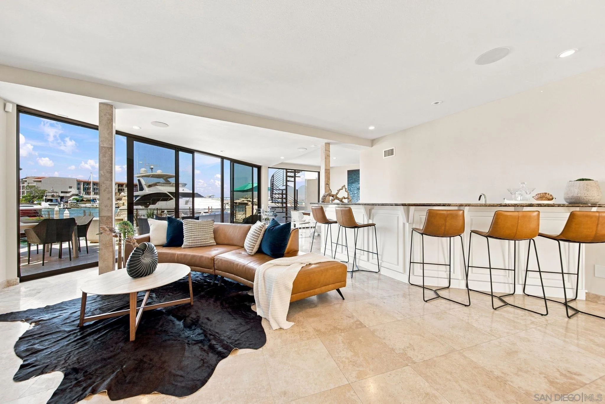 Open-plan living room and kitchen with marina views through floor-to-ceiling windows.