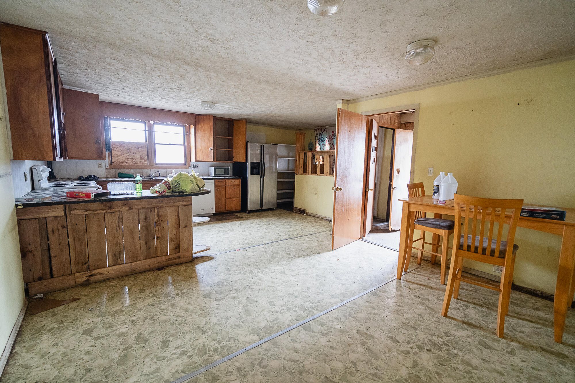Kitchen and dining area with wood cabinets, a dark-countertop peninsula, and a small wooden table.