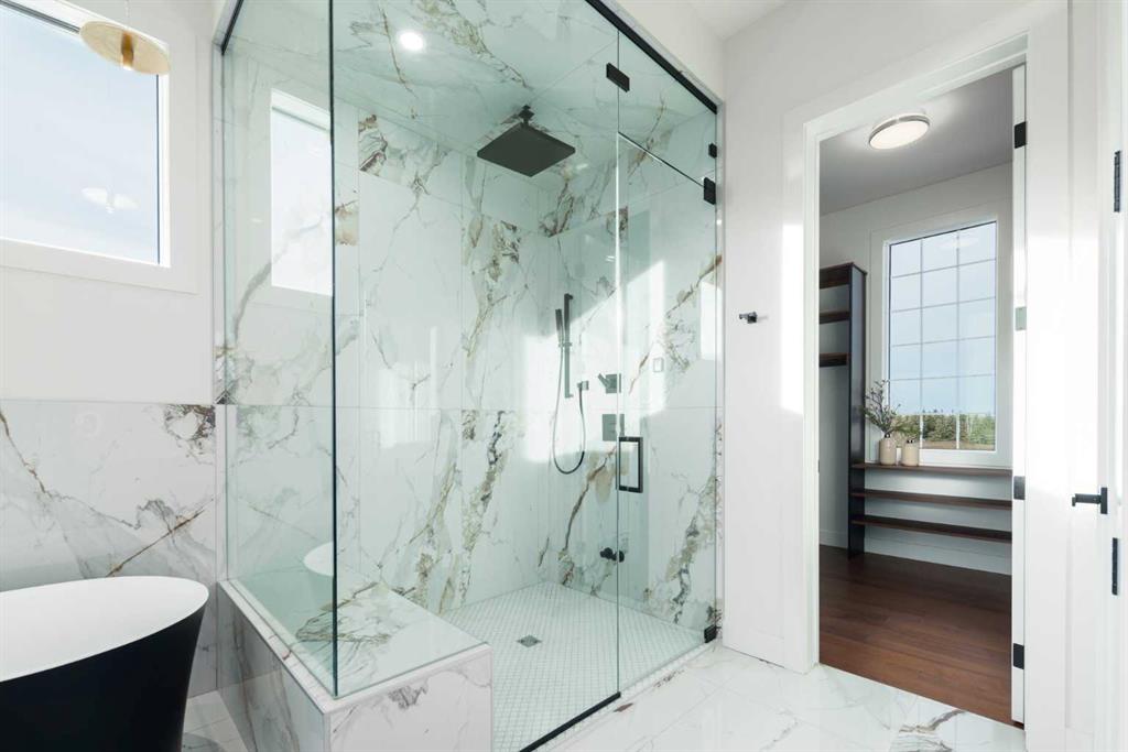 Marble bathroom with a glass walk-in shower and freestanding soaking tub.