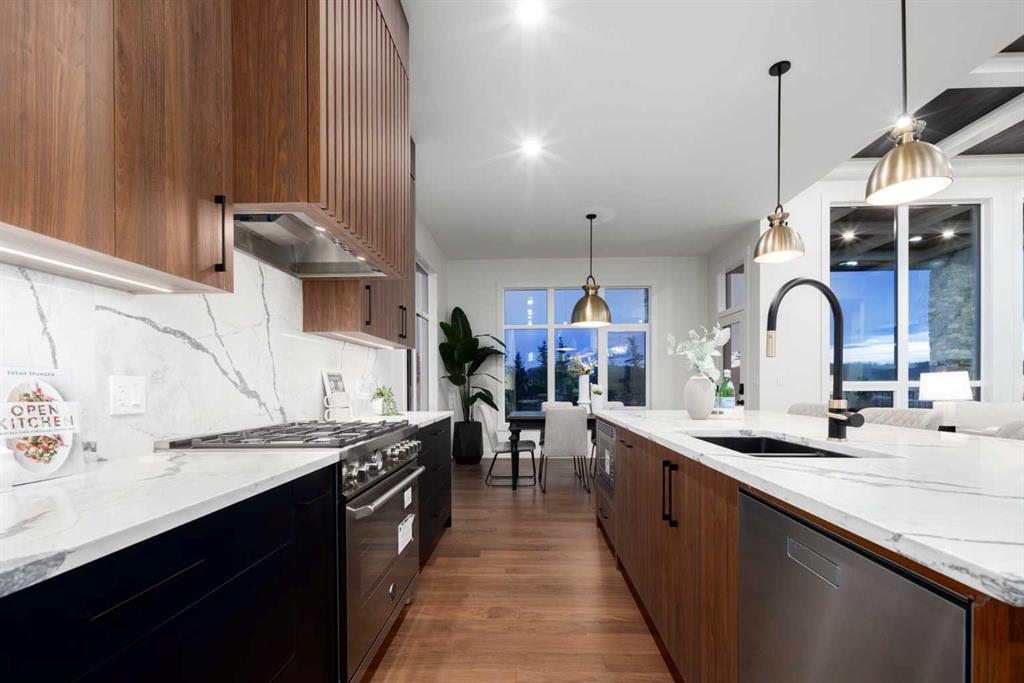 Modern kitchen with walnut cabinetry, veined stone counters, stainless appliances, and a large island.
