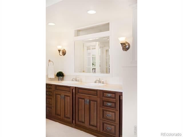 Bathroom with a long dark wood double vanity, two sinks, and a large mirror.