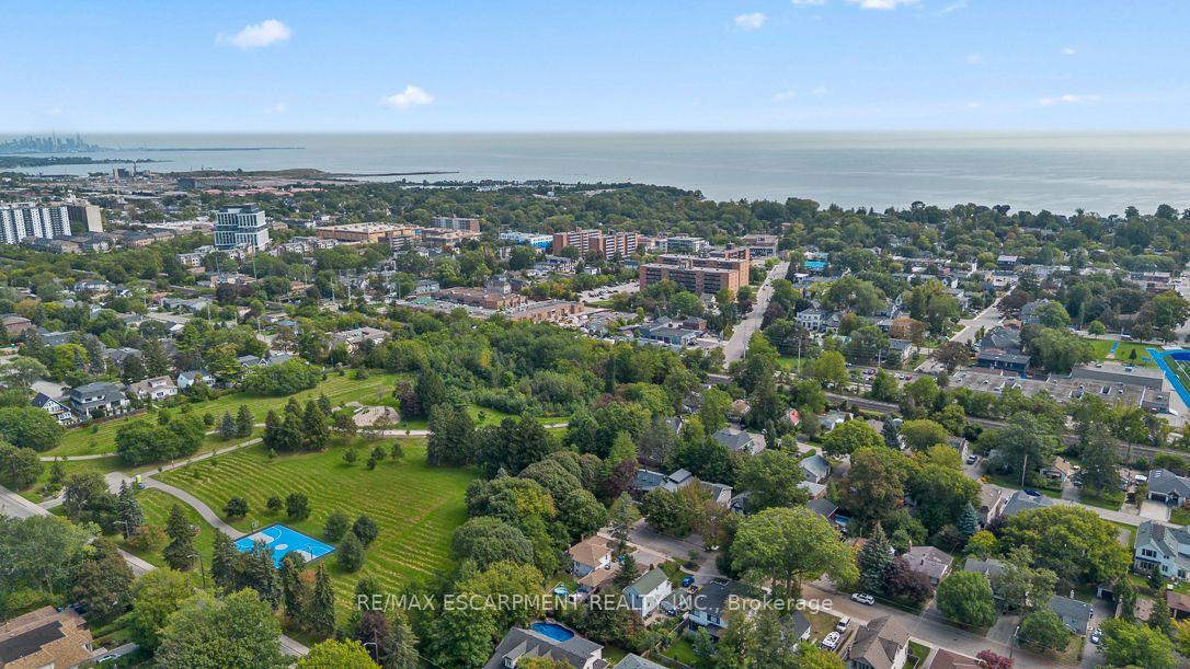 Aerial view of a leafy Mississauga neighborhood, park, and pool beside the Lake Ontario shoreline.