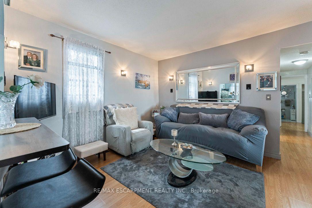 Furnished living room with a gray sofa, glass coffee table, and large wall mirror.
