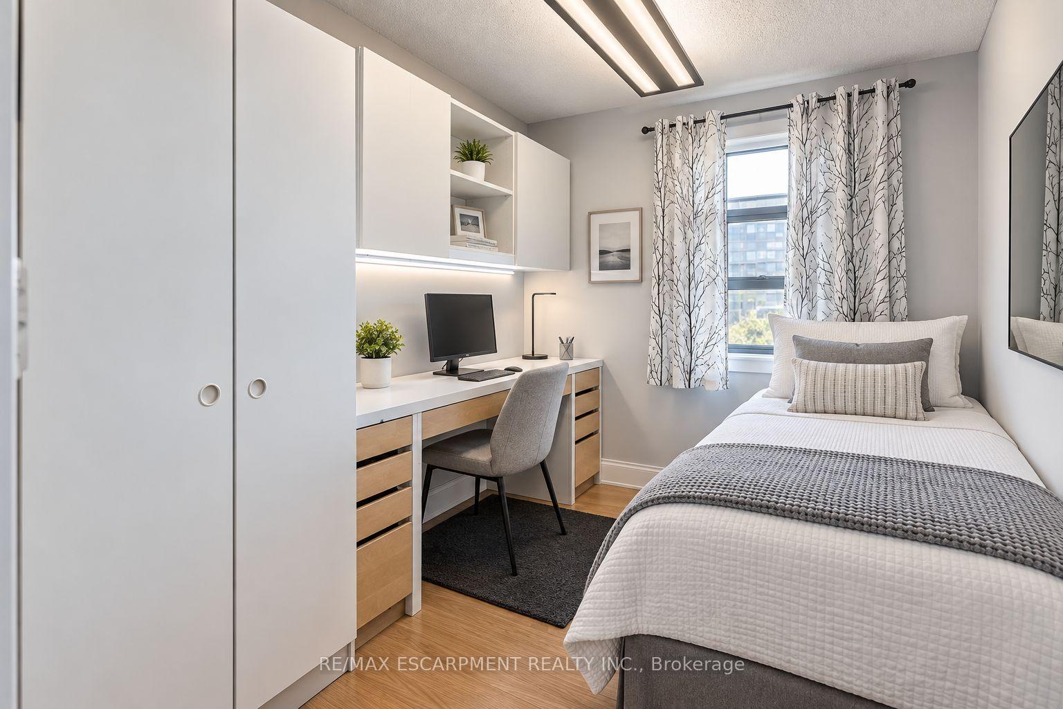 Staged bedroom with a built-in desk, white cabinetry, and a single bed beside a curtained window.