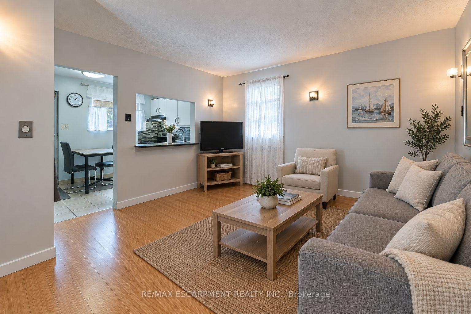 Living room with gray sofa, wood coffee table, and an open pass-through to the kitchen.