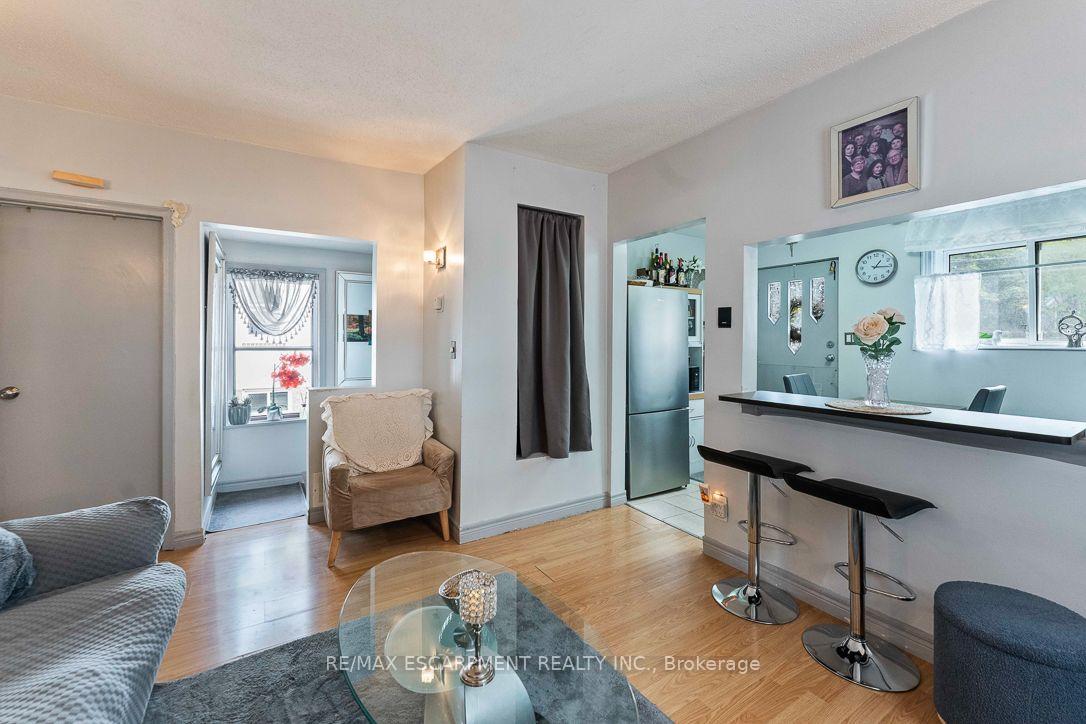 Living and dining area with hardwood floors, a glass coffee table, and a breakfast bar.