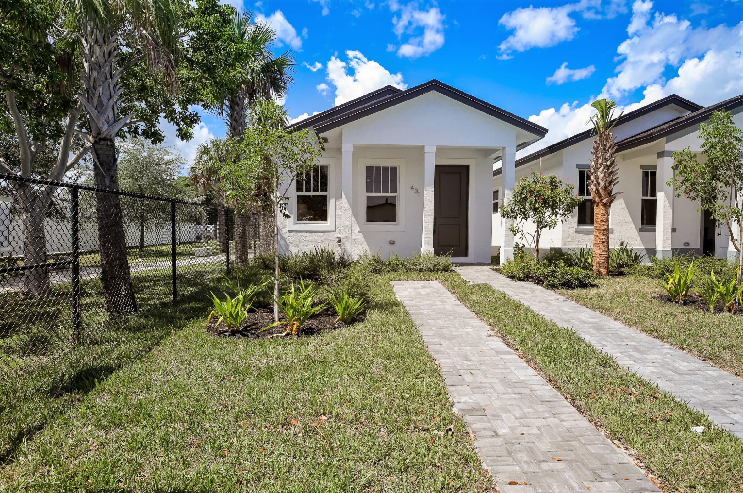 431 S F Street home with a white facade, landscaped lawn, and paver walkway.