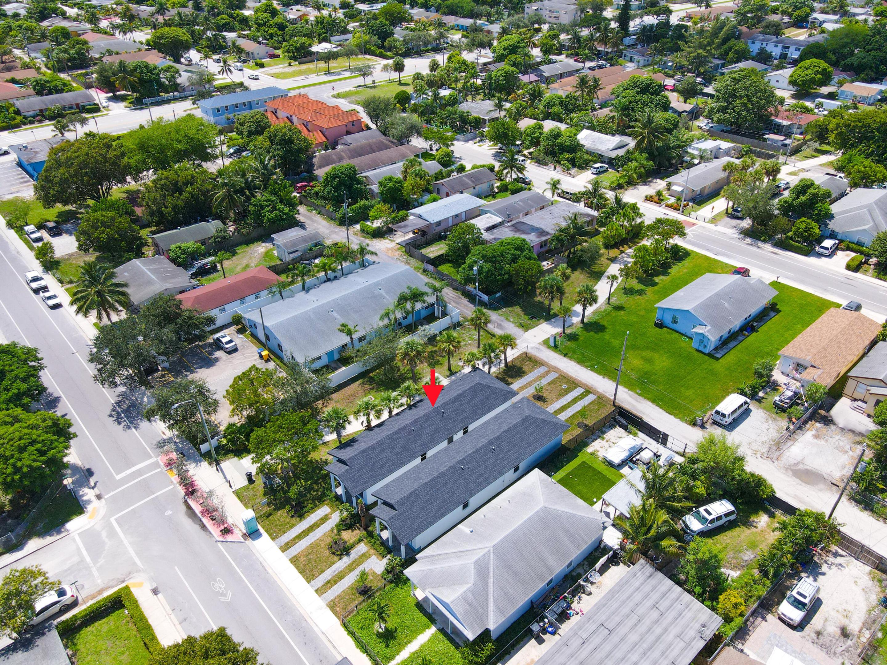 Aerial view of 431 S F Street, marked by a red arrow among palm-lined homes near a street intersection.