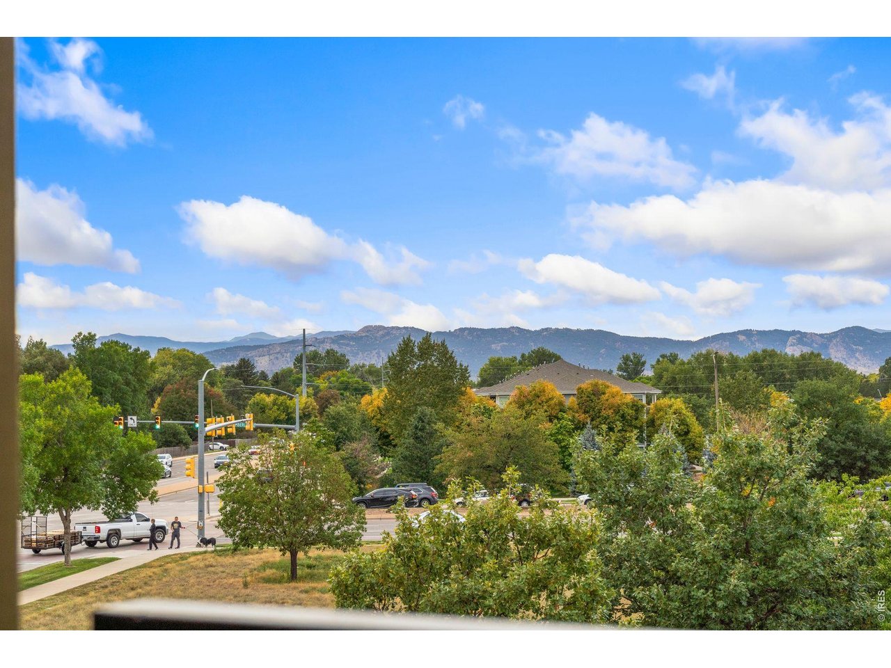 Mountain view over autumn trees, a nearby street and traffic lights.