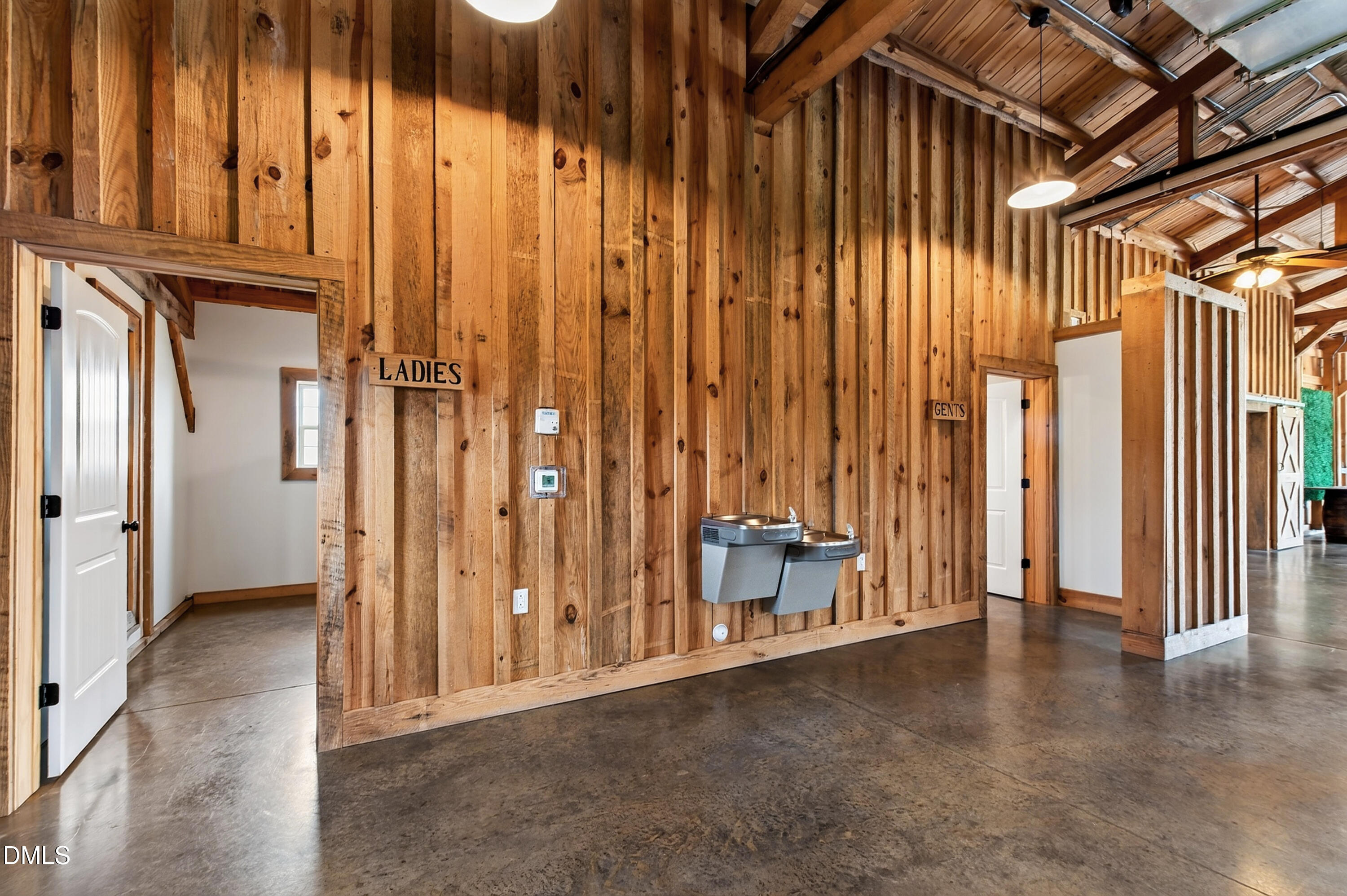 Rustic wood-paneled interior with exposed rafters, drinking fountains, and marked restroom doors.