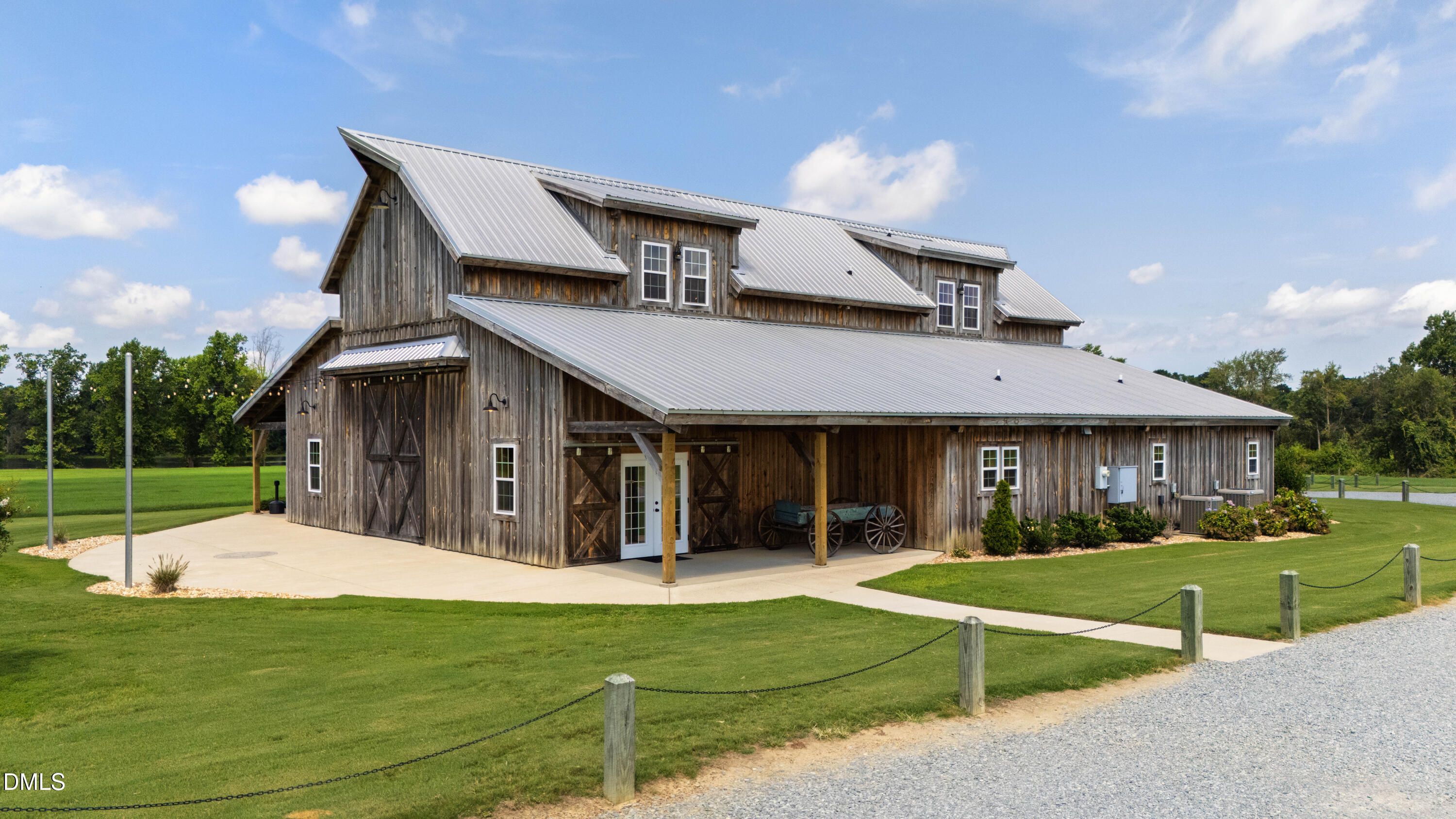 Rustic timber building with a silver metal roof, covered entrance, and manicured lawn.