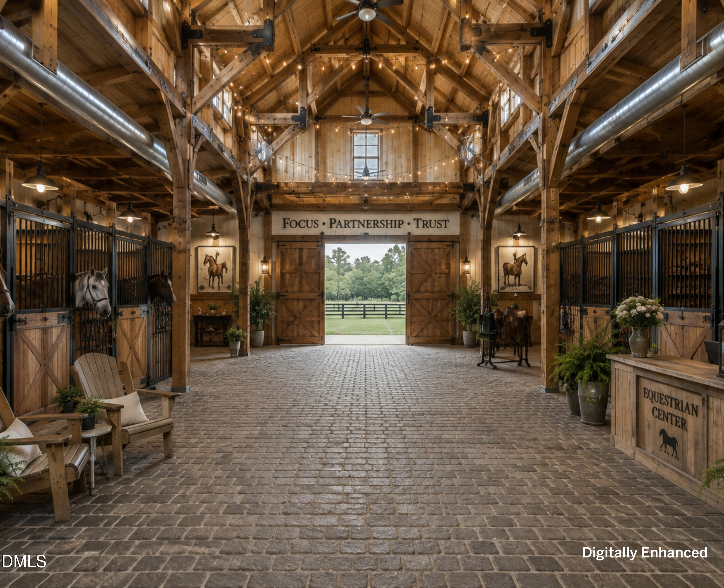 Equestrian center interior with timber beams, horse stalls, and open doors to a green pasture.