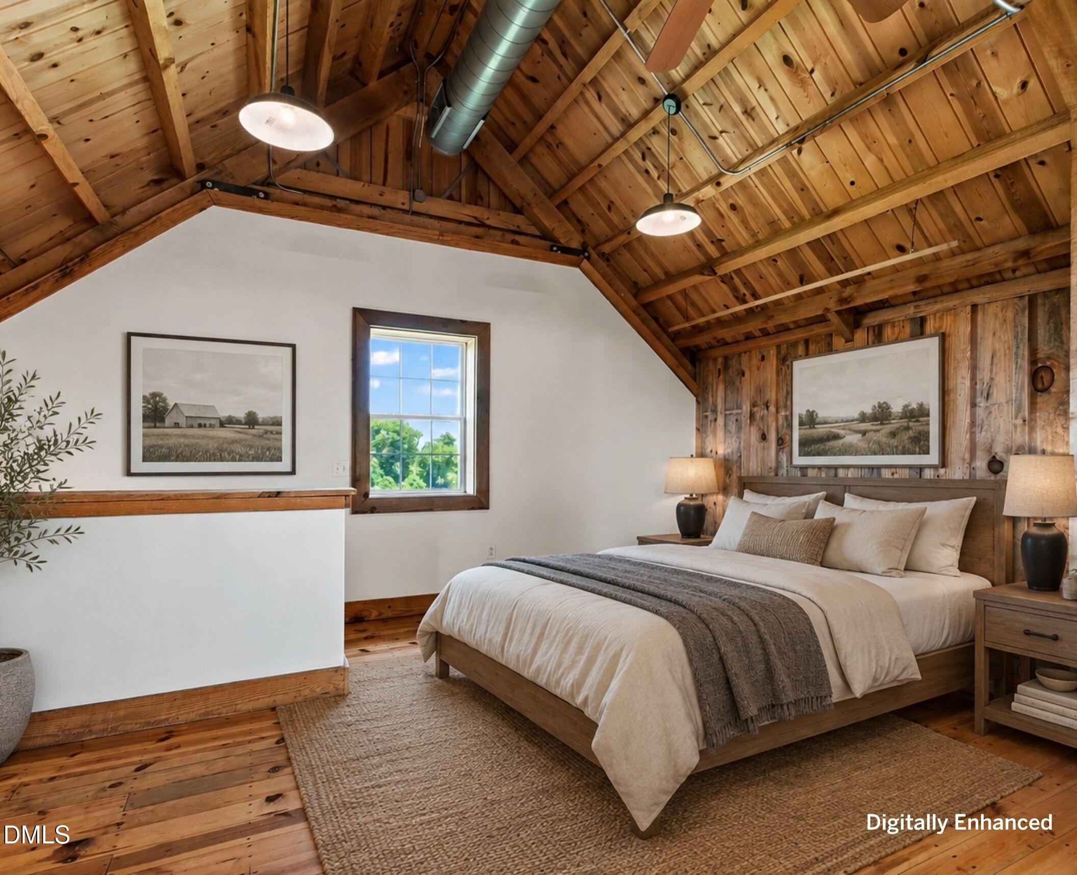 Bedroom with a large bed beneath a vaulted exposed timber ceiling and wood plank floors.