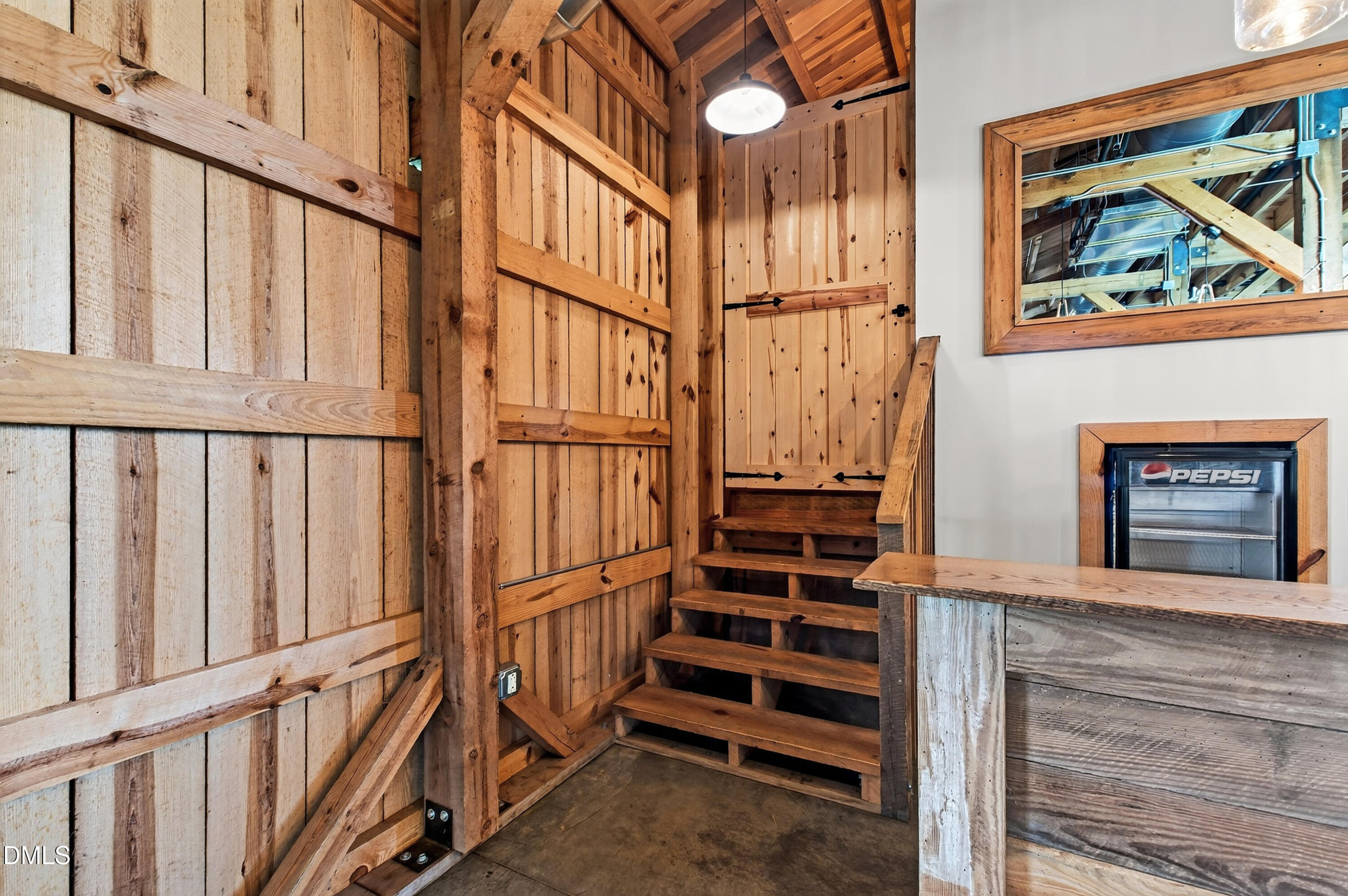 Rustic timber interior with a wooden staircase, rough-hewn counter, and Pepsi refrigerator.