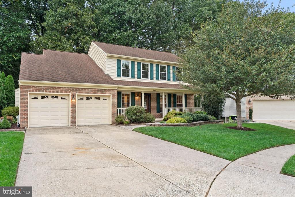 Two-story suburban home with a brick-accented facade, covered porch, and two-car garage.