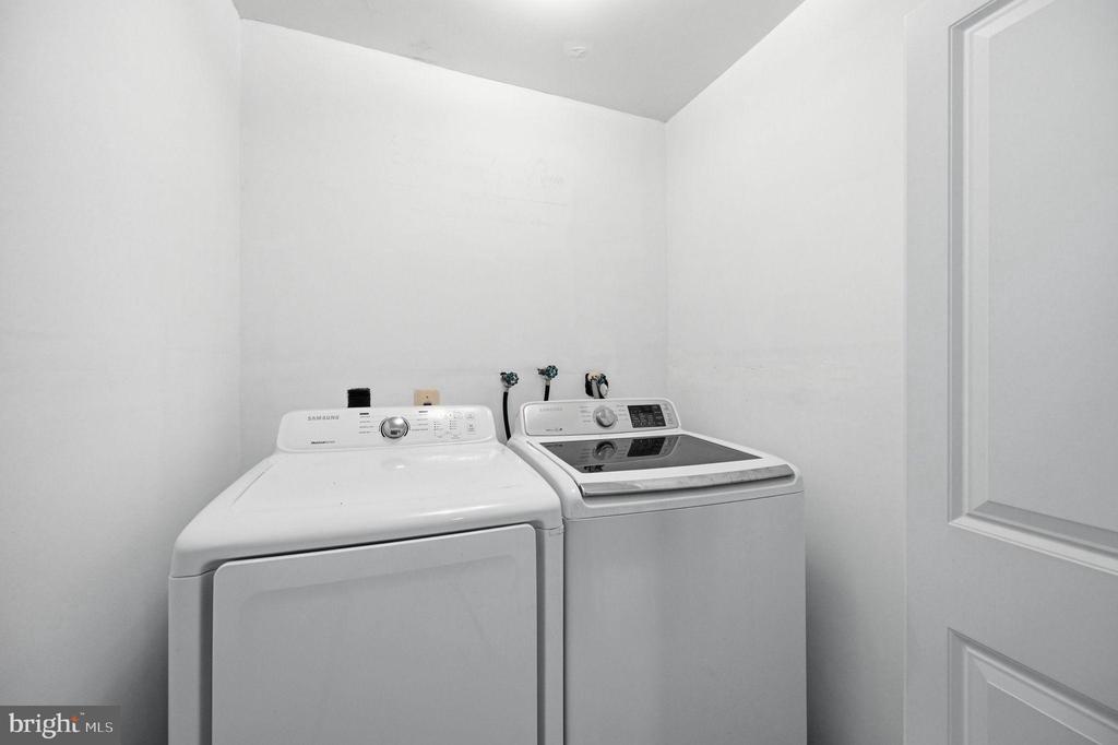 Laundry room with a front-loading dryer beside a top-loading washing machine.